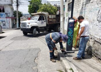 Limpian en N. R. banquetas y postes de la basura que les pegan